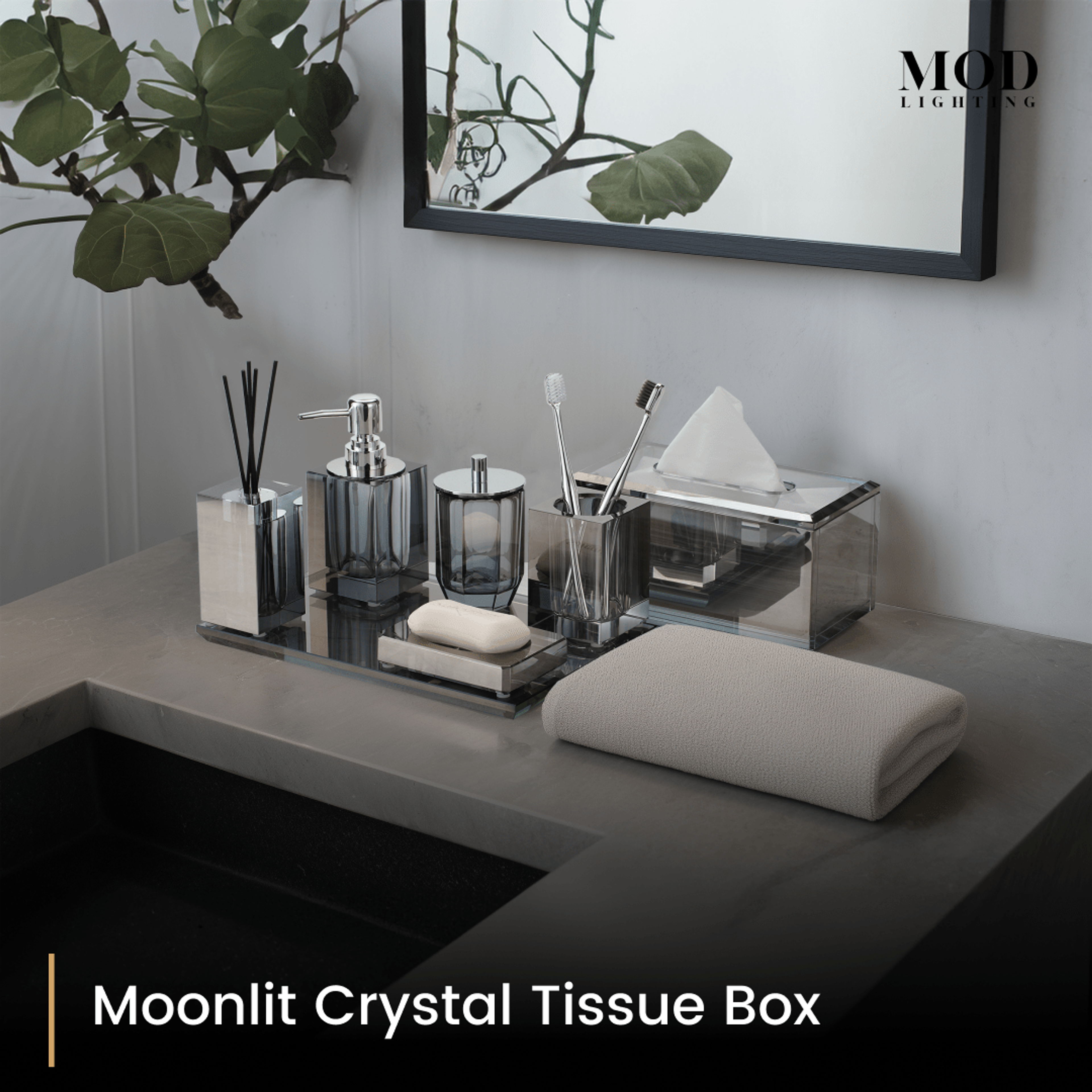 Moonlit Crystal Tissue Box and smoky crystal bath set on a mirrored tray on a dark vanity below a mirror