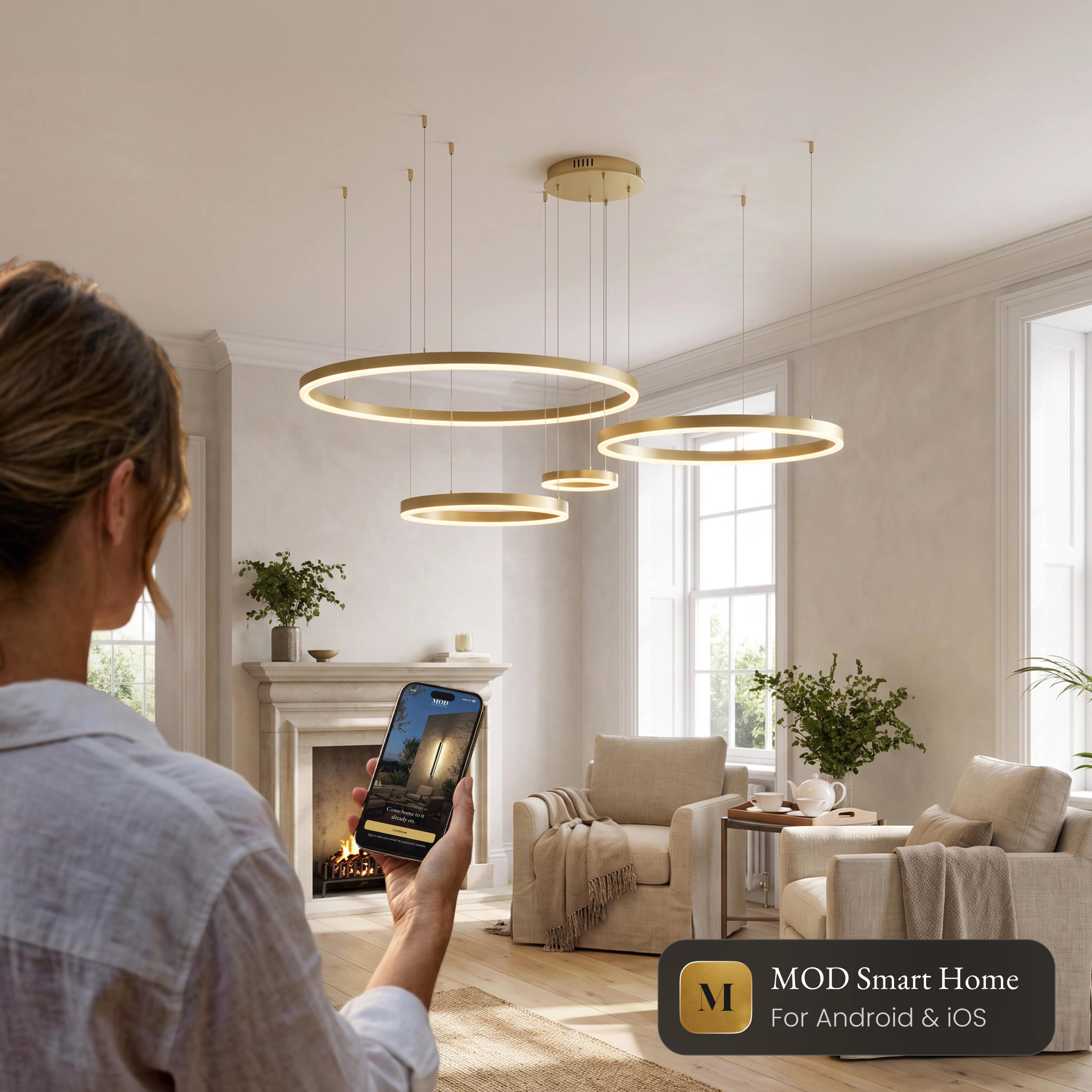Charlotte Smart ring chandelier in a living room, controlled from the MOD Smart Home app on a phone