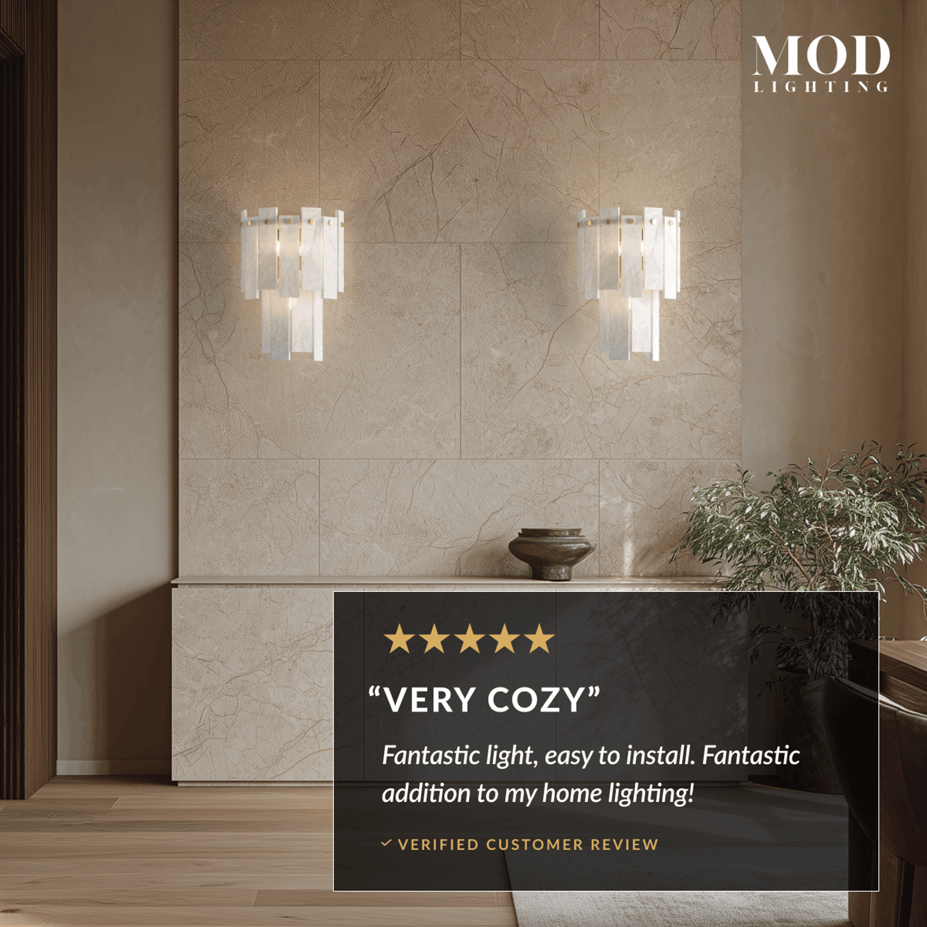 Velina Sconce gold wall light with tiered alabaster panels casting a warm glow on a tiled wall