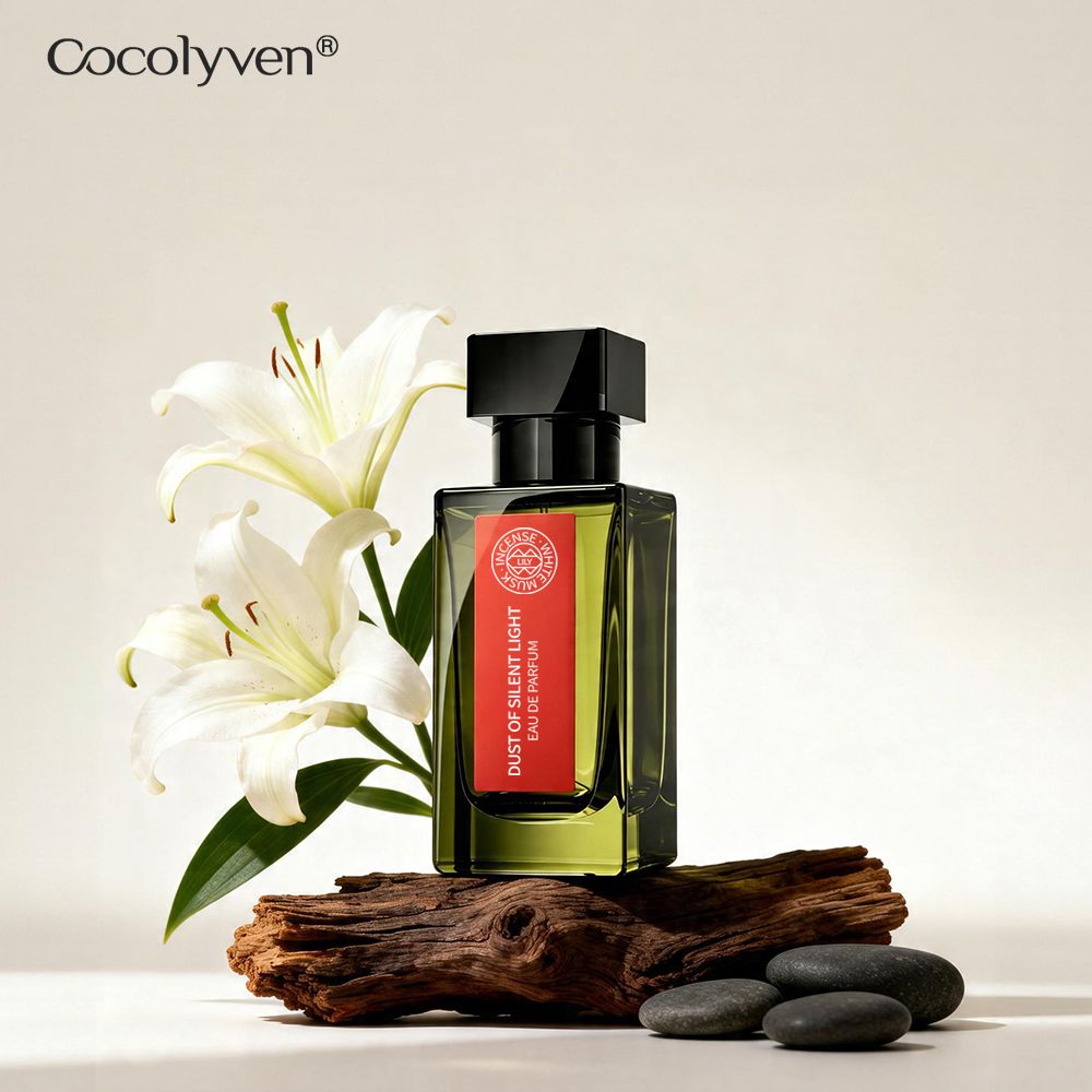 COCOLYVEN Silent Light Dust Perfume 50ml olive-green bottle with red label beside white lilies — ready stock wholesale from Guangzhou, China