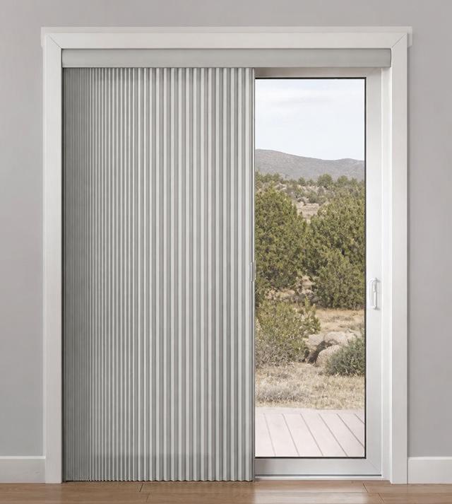 Vertical honeycomb shades with light-blocked fabric on glass door
