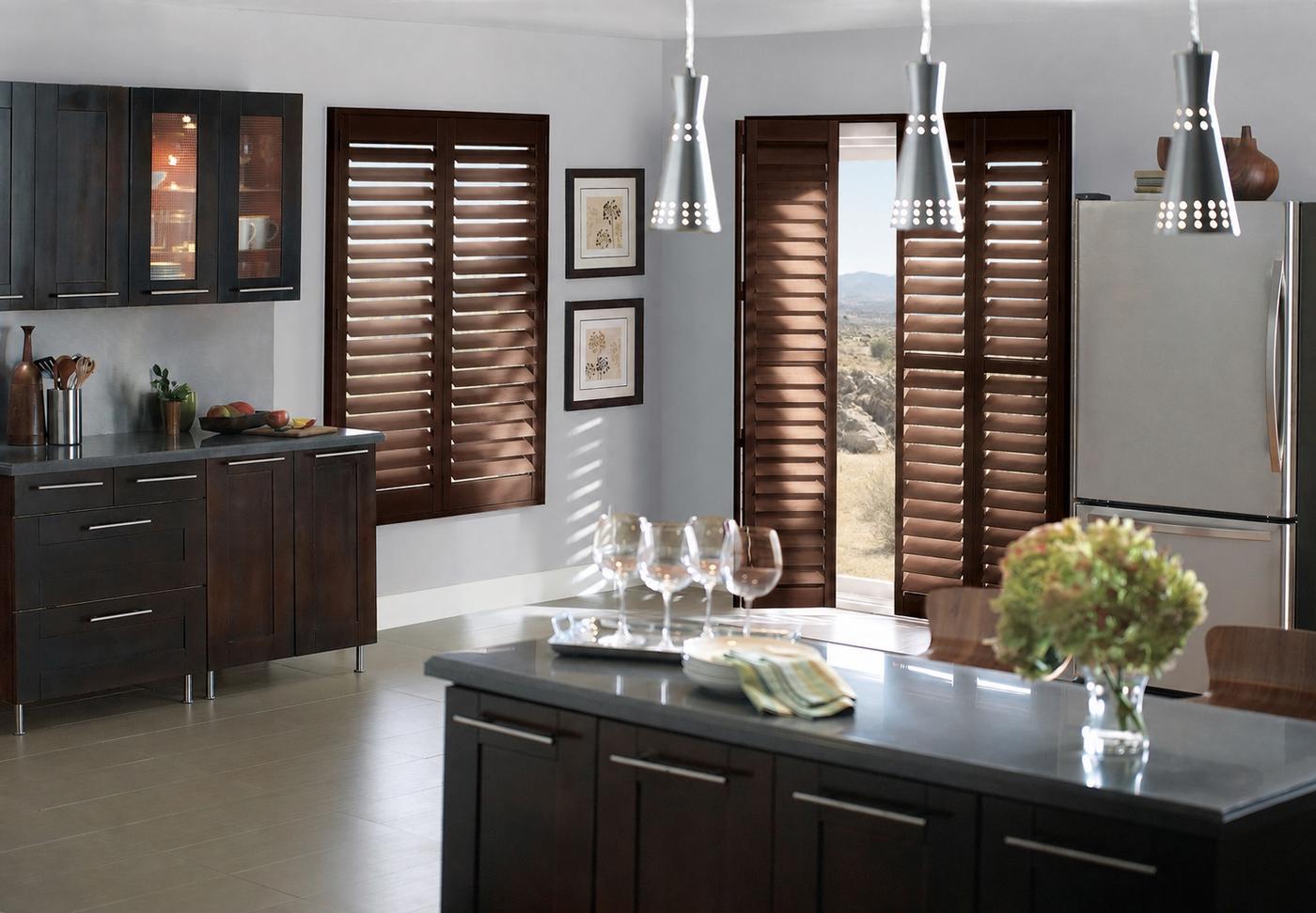 Wood shutters with bi-fold hinge and track system in kitchen on window and door