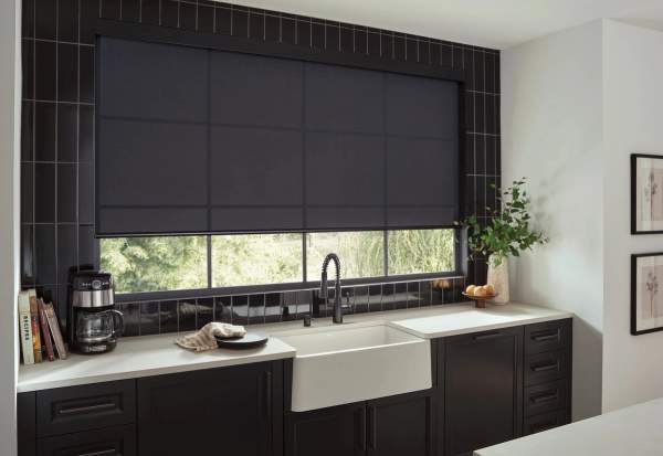 Black light filtering roller shade over kitchen sink and counter