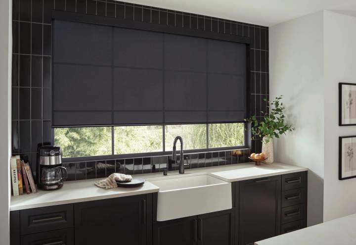 Black light filtering roller shade over kitchen sink and counter
