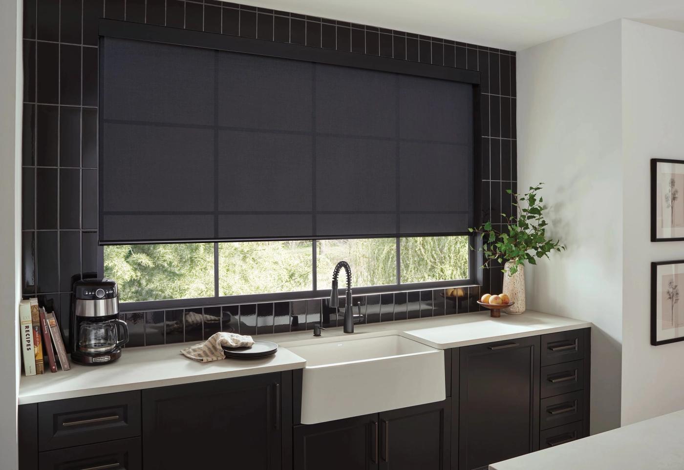 Black light filtering roller shade over kitchen sink and counter