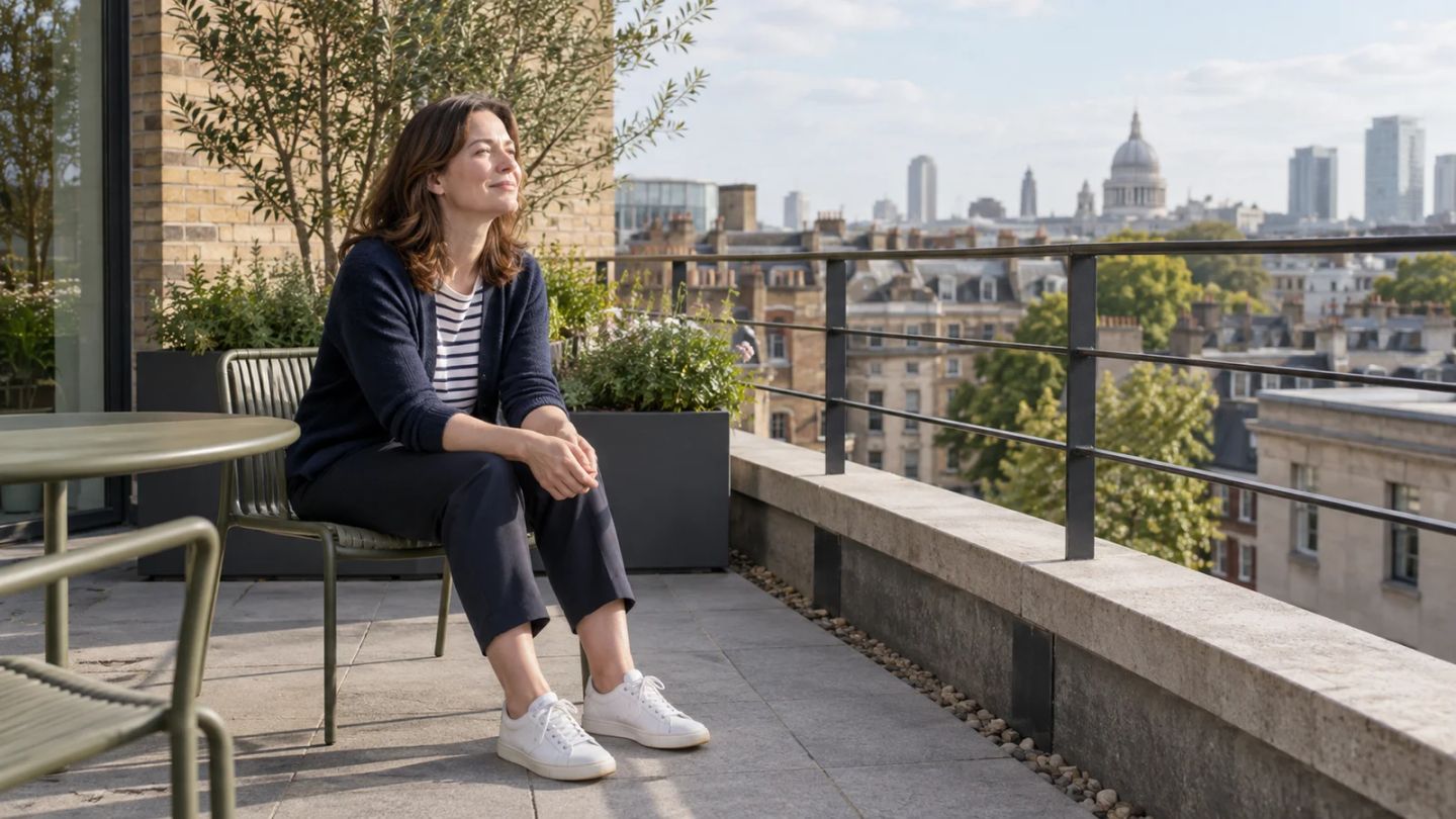 A woman takes a quiet daylight break on an office terrace.