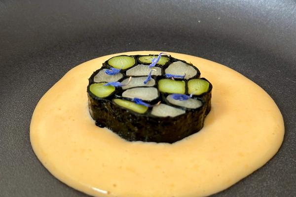 ein schwarzer Teller mit einem Mosaik aus Spargel