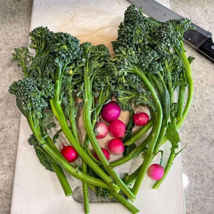 radishes and broccolini on a cutting board