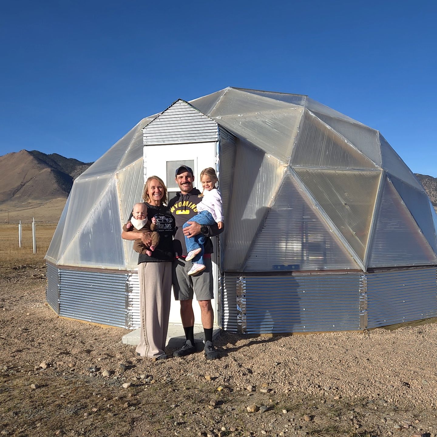 The Waugh family standing outside their Wyoming dome