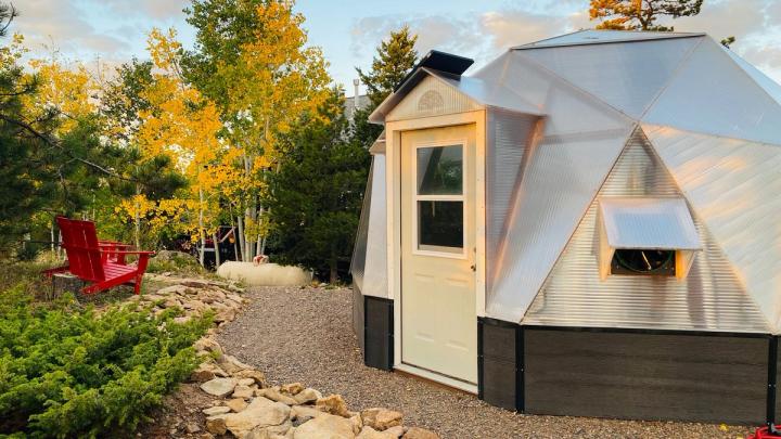 The yellow light from golden fall aspens reflecting off the front of a Growing Dome