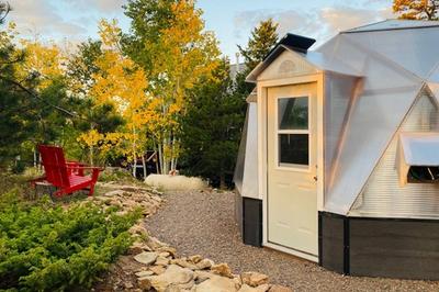 growing dome greenhouse with red adirondack chair