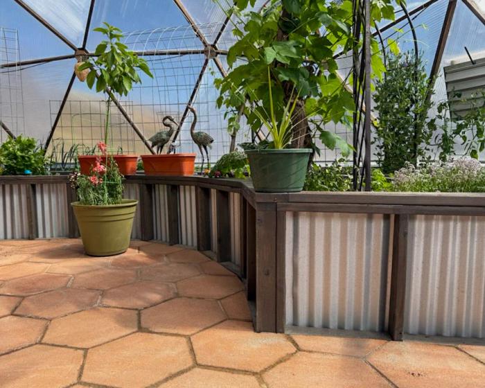galvanized raised garden beds inside a growing dome greenhouse with octagonal paver tile flooring