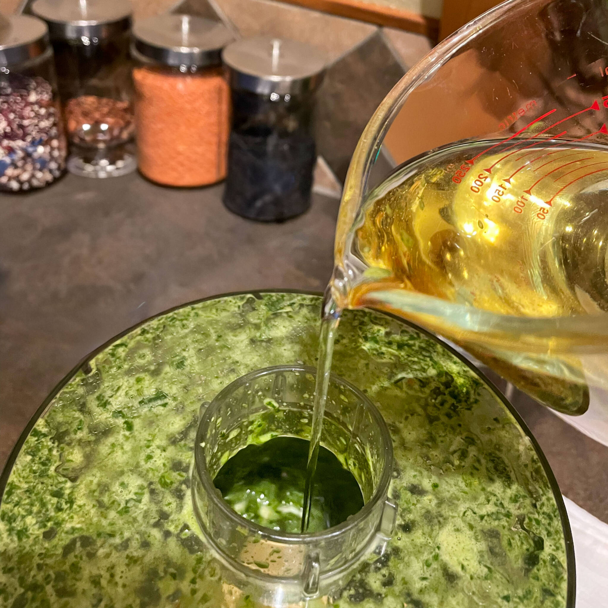 adding oil to the food processor