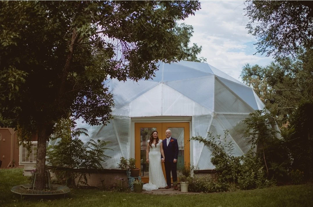 Wedding couple posing for a photo in front of Growing Dome greenhouse