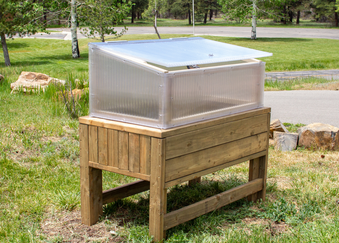 polycarbonate cold frame on top of an elevated wooden garden bed