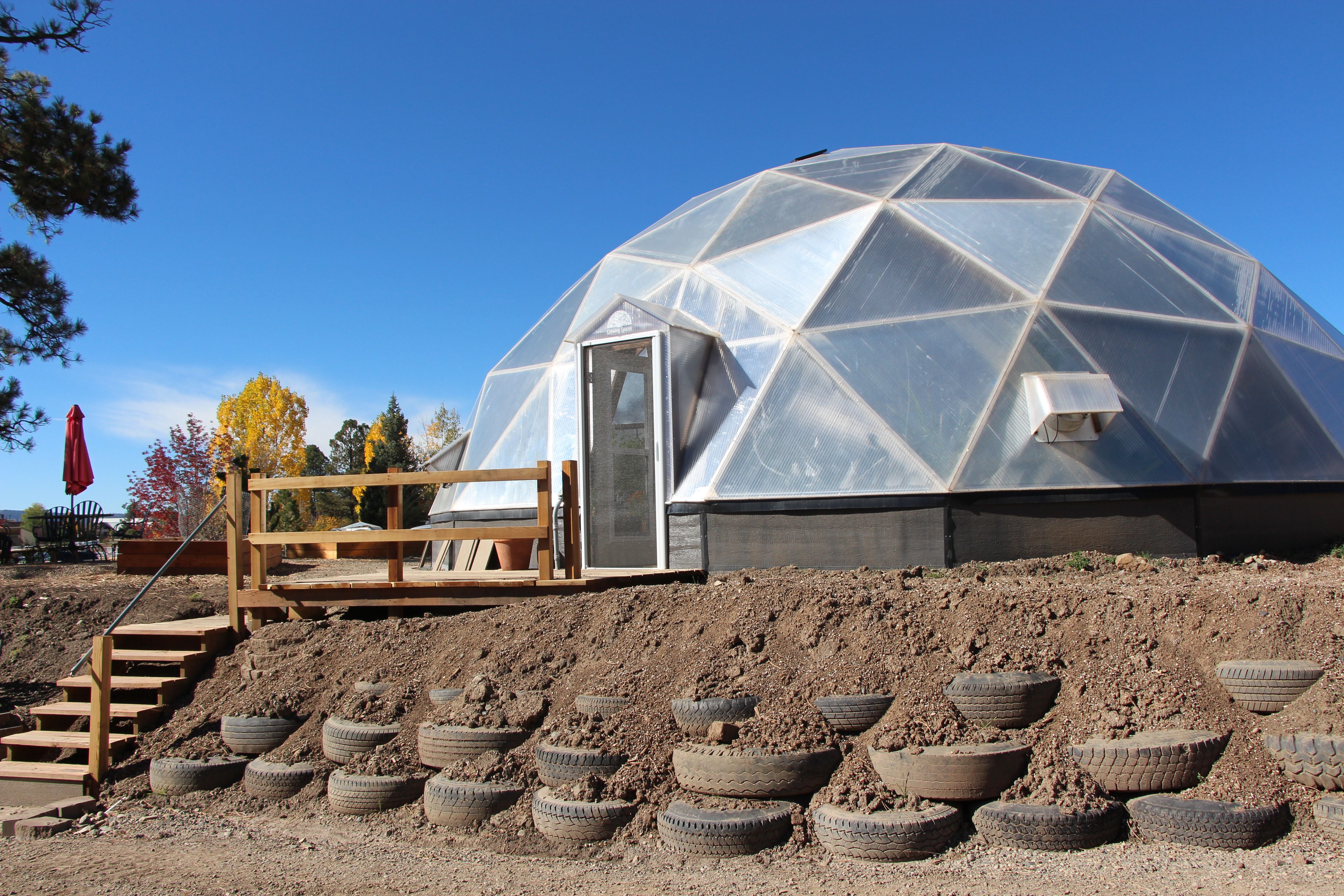 tires used as a retaining wall to level the site for a 42-foot growing dome greenhouse