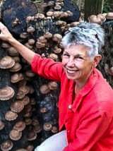 woman in front of a wall of mushrooms growing