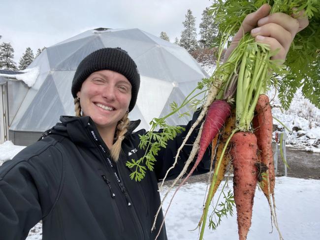 Growing Spaces staff showcasing winter harvest outside a 33' Growing Dome