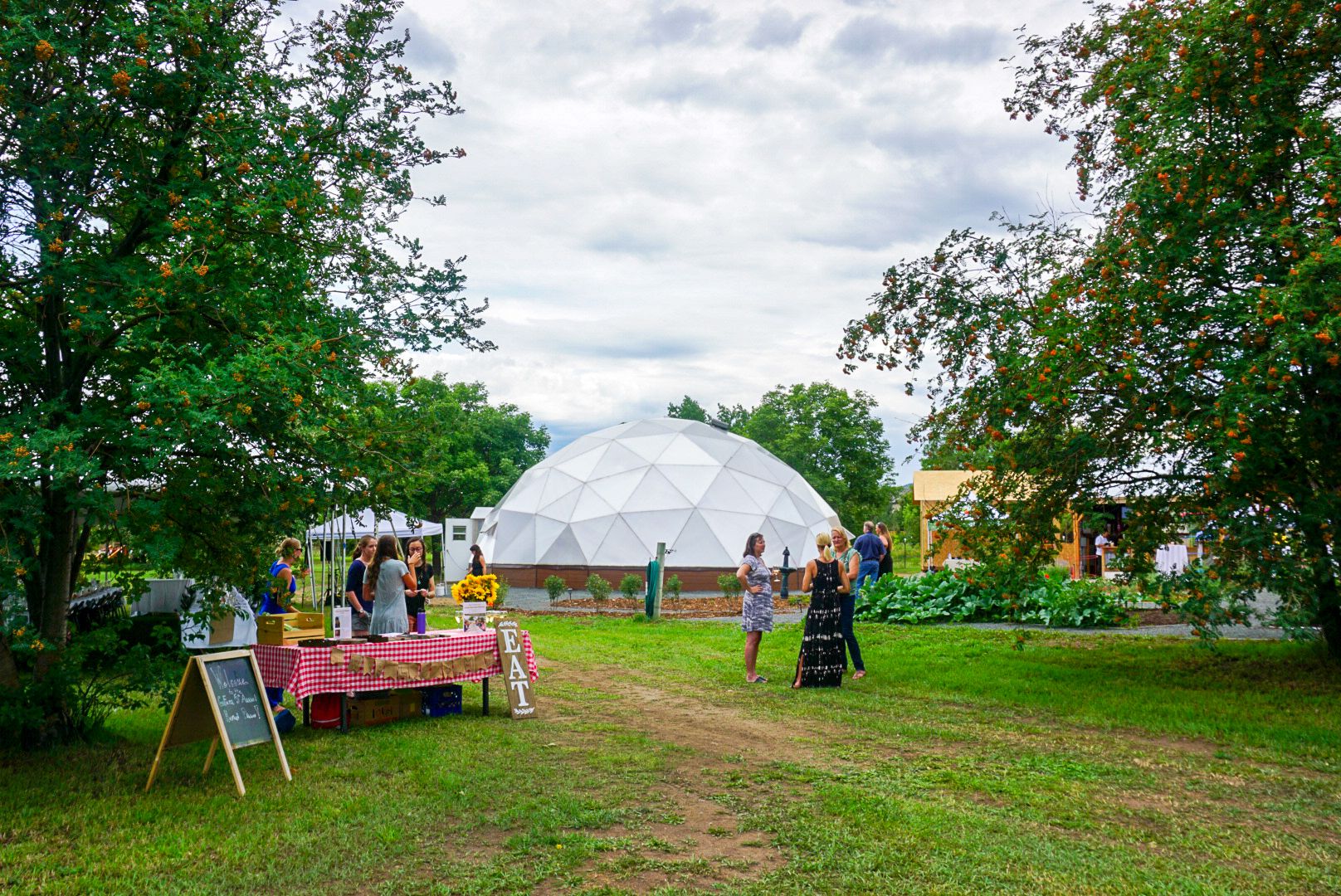 people standing outside a geodesic growing dome greenhouse event
