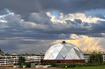 Growing Dome greenhouse surrounded by Midwest clouds