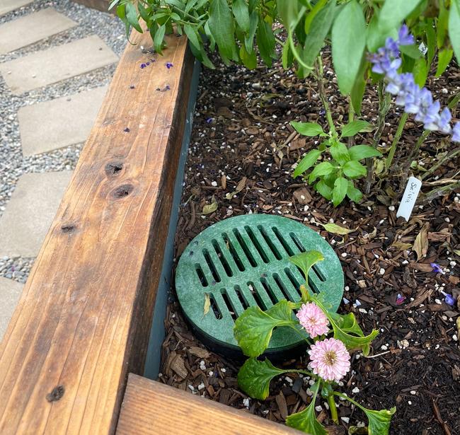 landscaping grate covering undersoil system in raised bed in a greenhouse