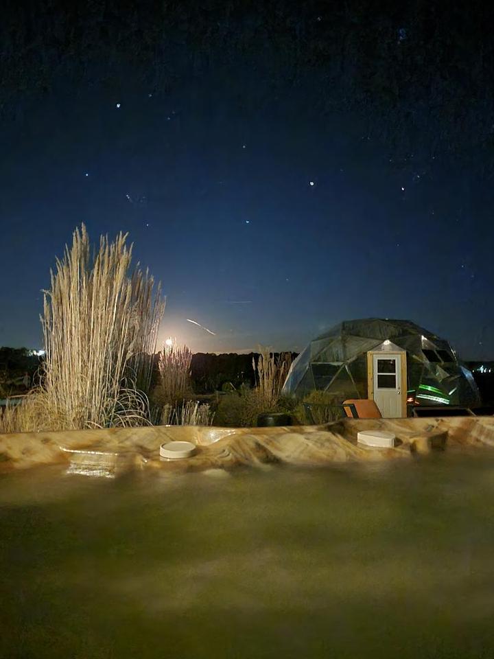 View from the hot tub of the night sky and ornamental grasses and geodesic greenhouse