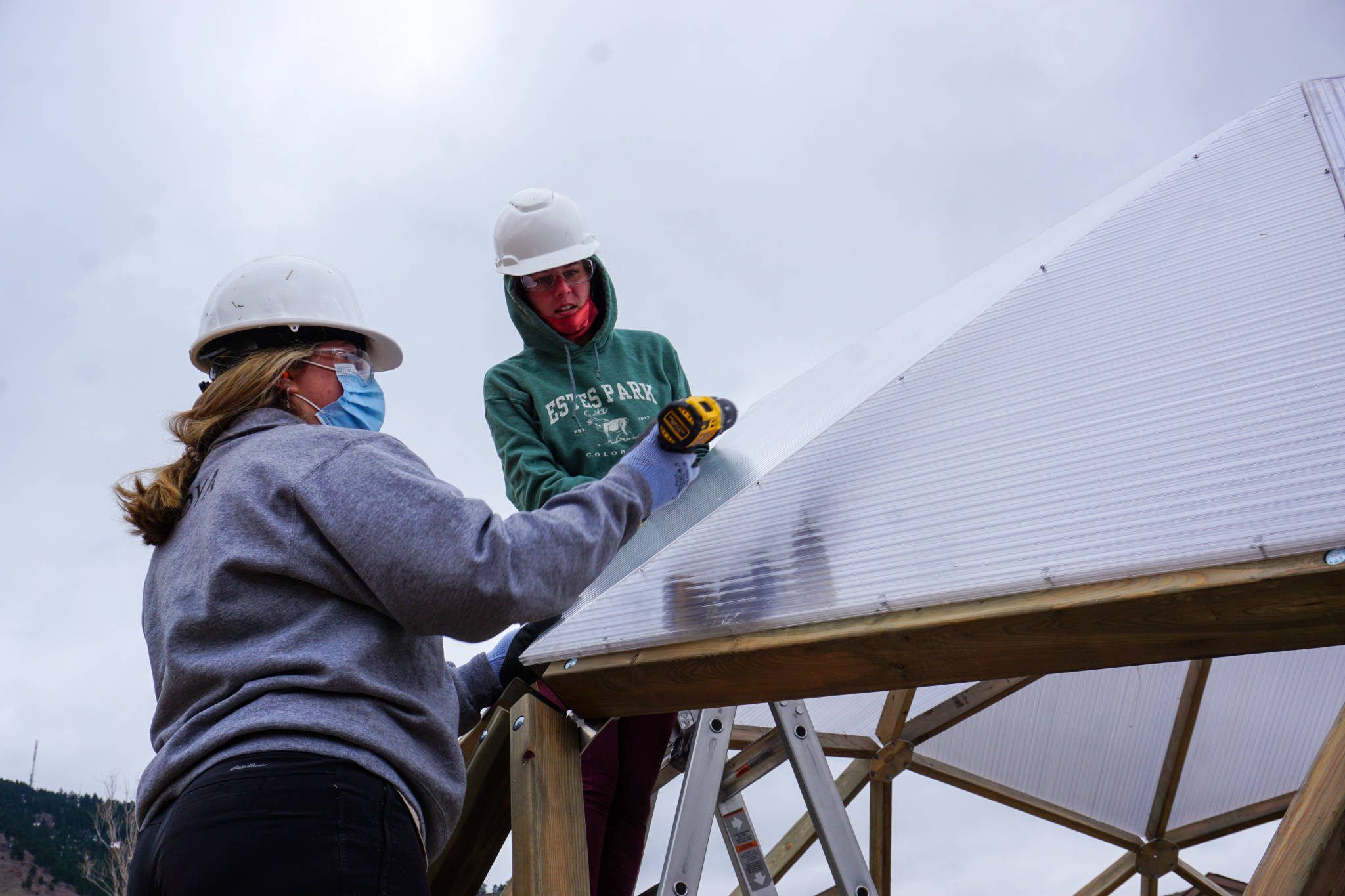 Students attaching polycarbonate to a greenhouse