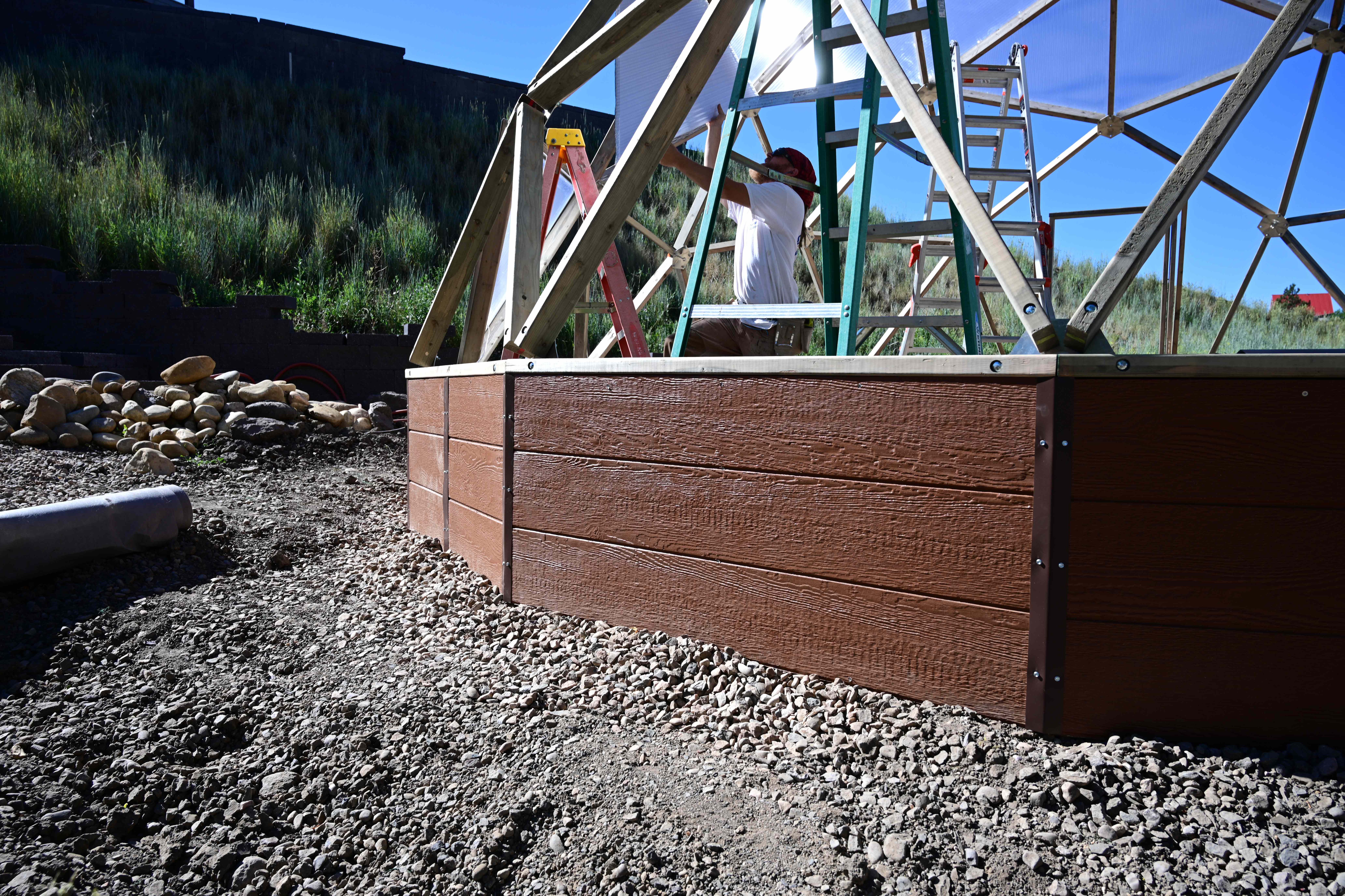 greenhouse being installed close up of foundation wall on gravel