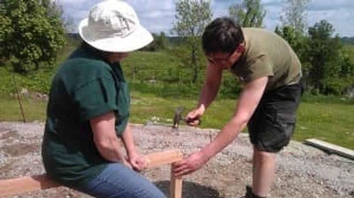 Crew assembling wall sections for a 26' Growing Dome greenhouse