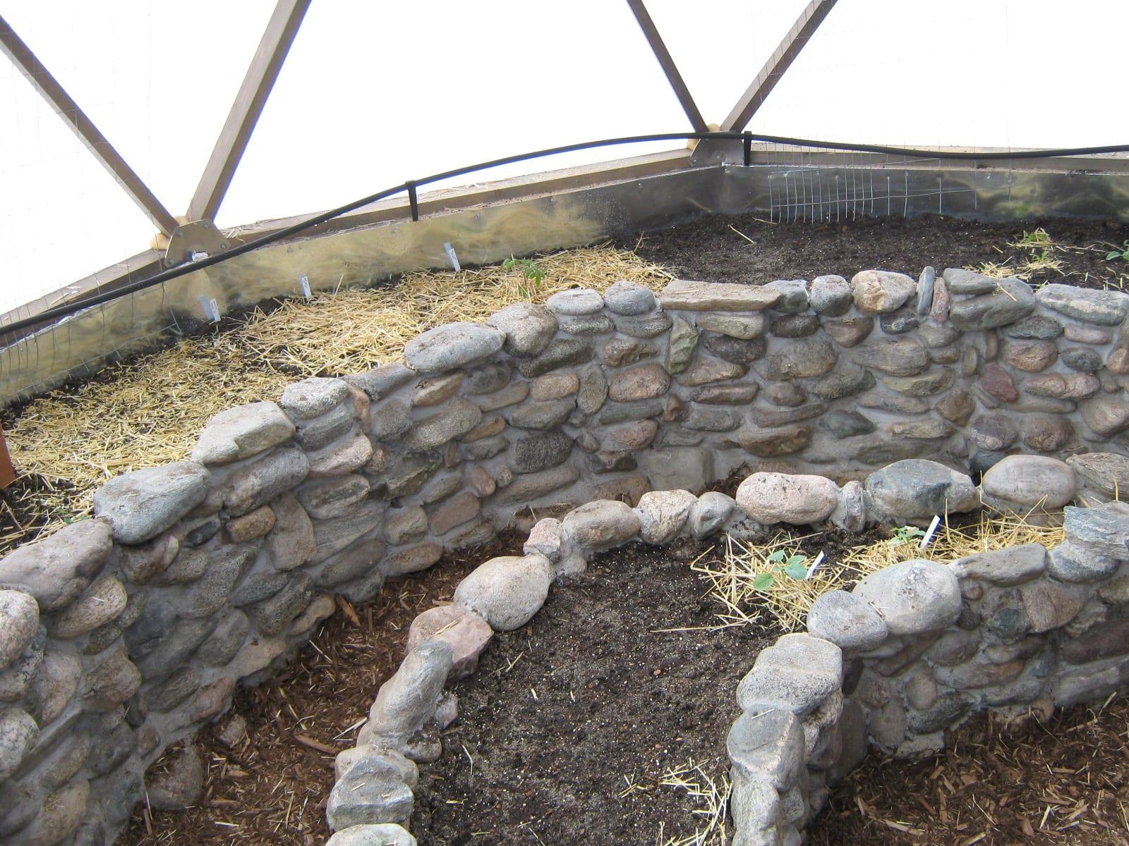 stone walls used to create raised beds within the greenhouse
