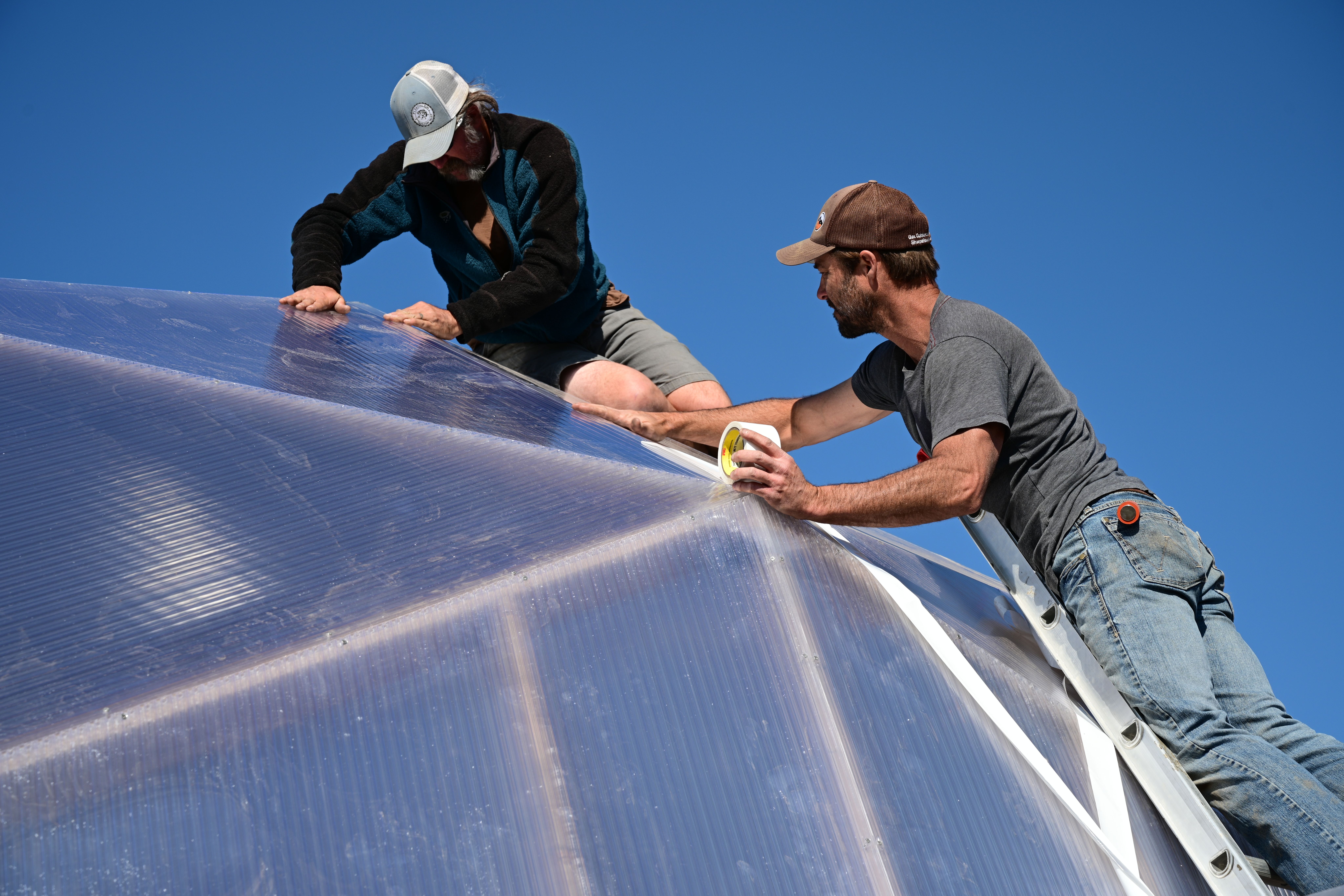 Two men working on a greenhouse