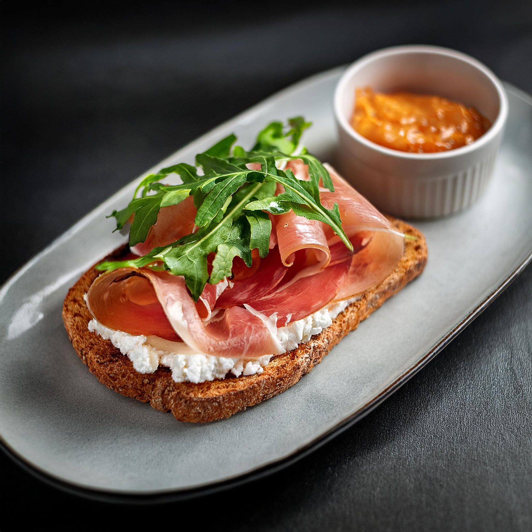 AI generated breakfast toast with goat cheese, ham, arugula, and fig jam