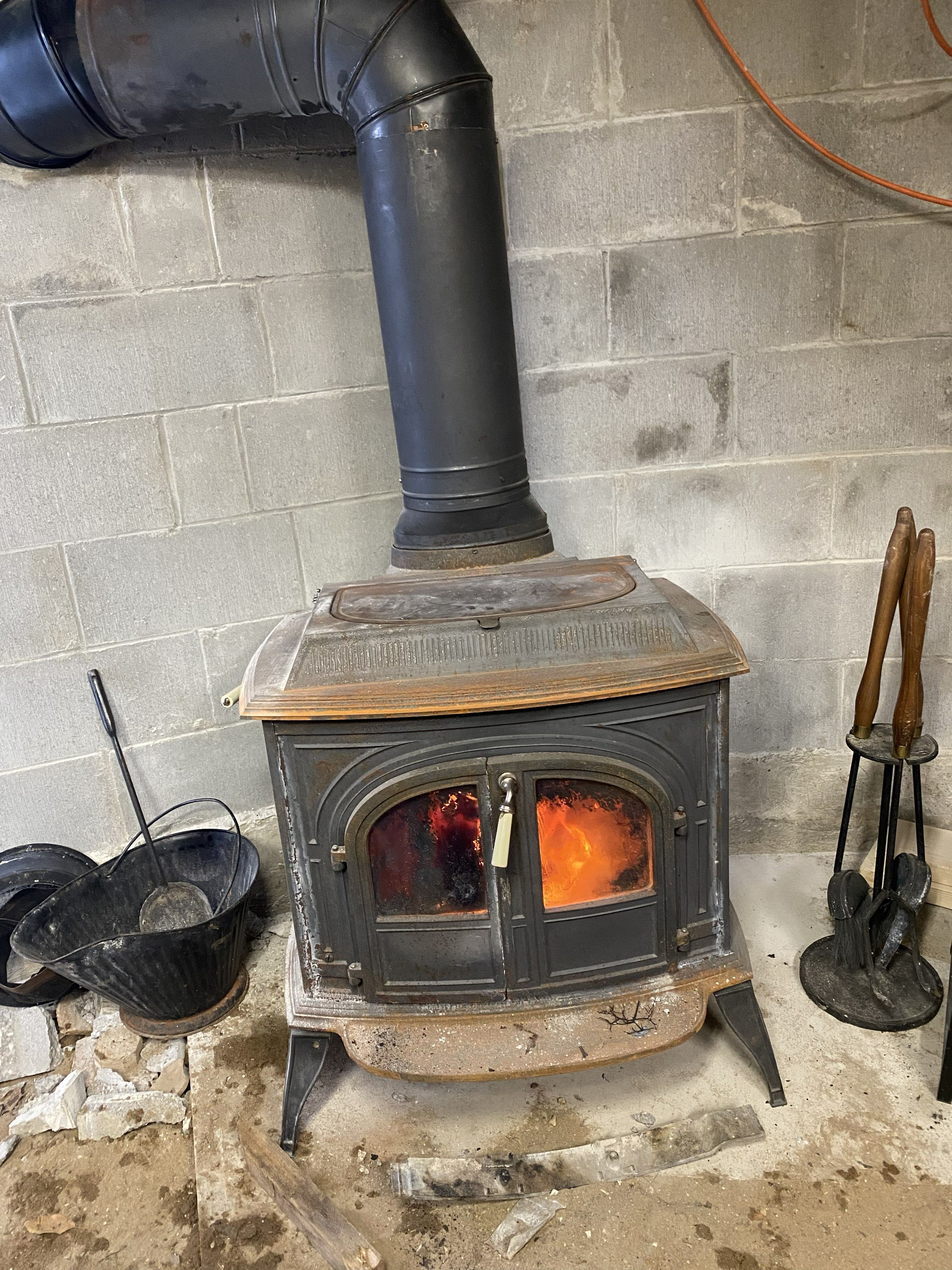 wood burning stove in the basement of the greenhouse against the cinder block wall