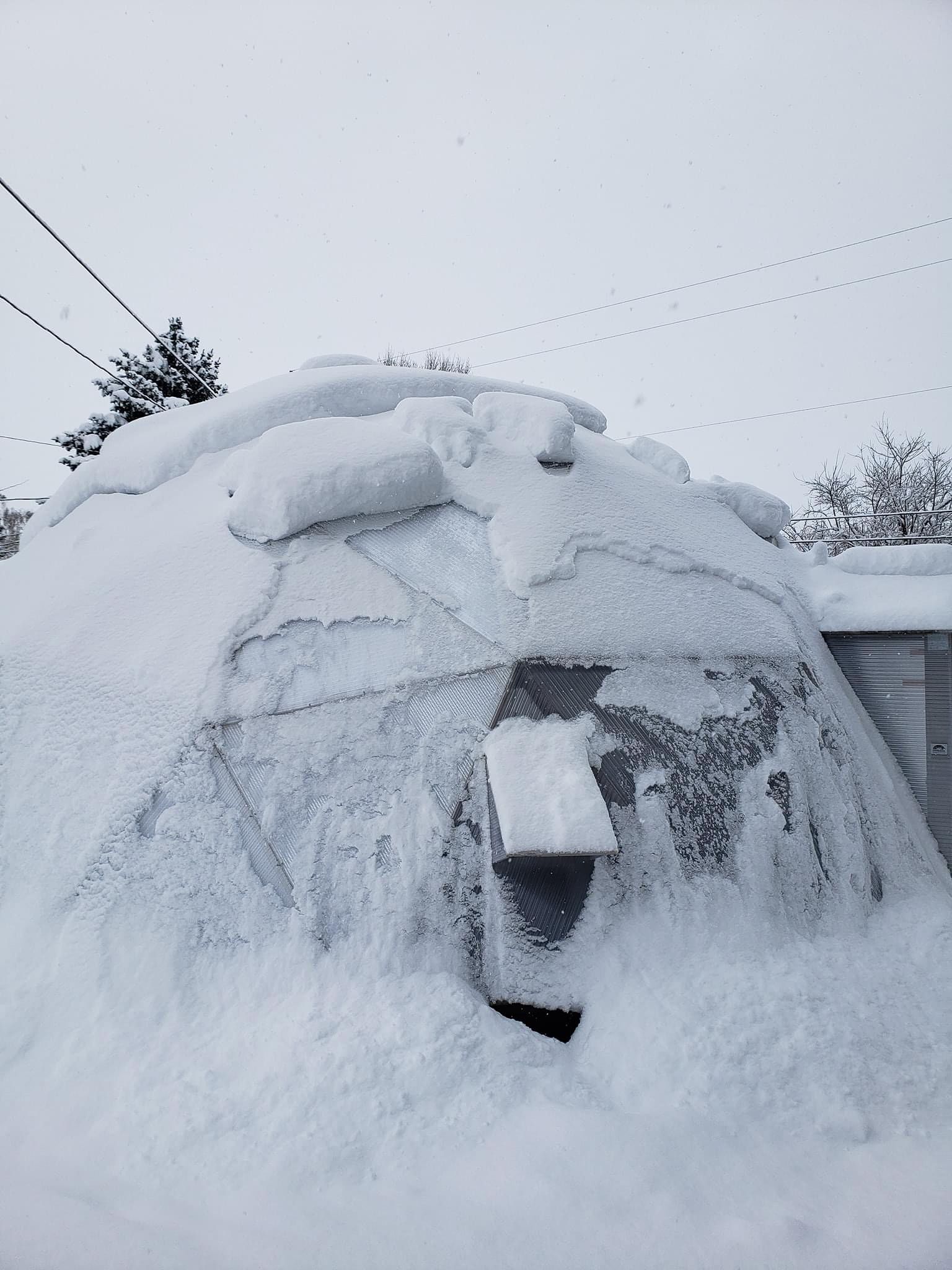 Snow shedding off of a dome shaped greenhouse