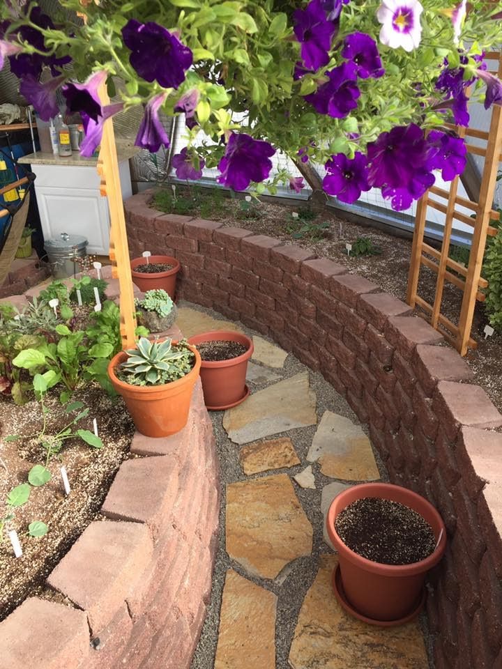 landscaping bricks used for raised beds with a flagstone and gravel floor inside the greenhouse