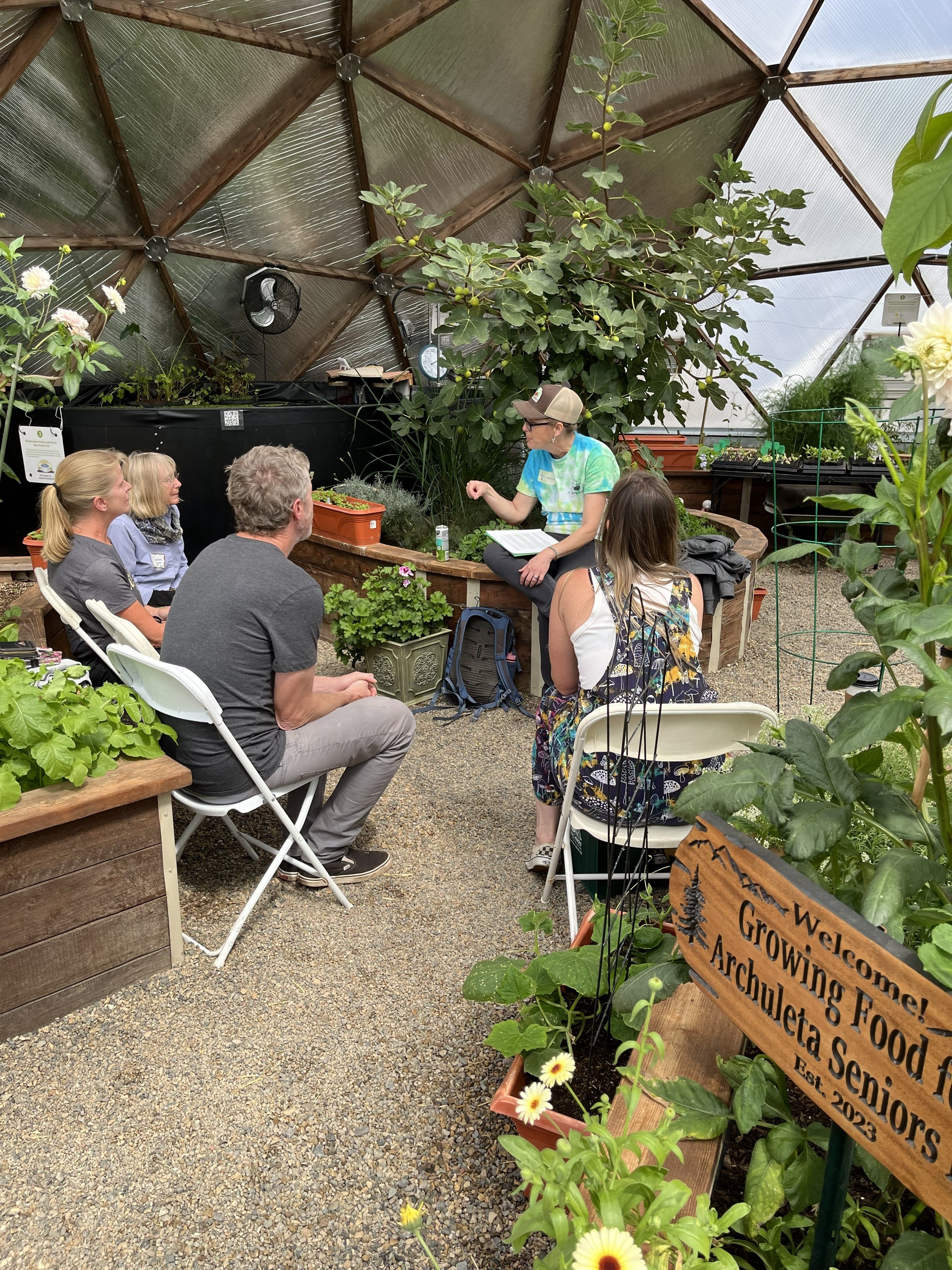 Growing Spaces employee teaching a hands-on gardening class inside a 42' Growing Dome greenhouse