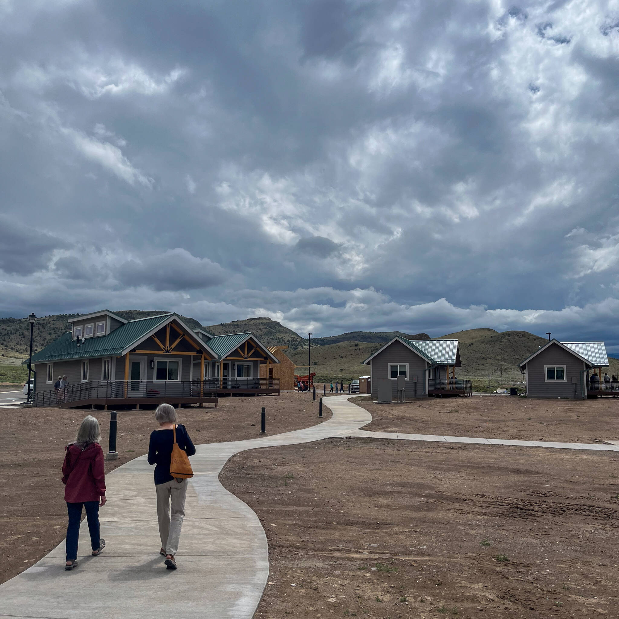 Two women walking down a pathway connecting the wellness center to the casitas on the property