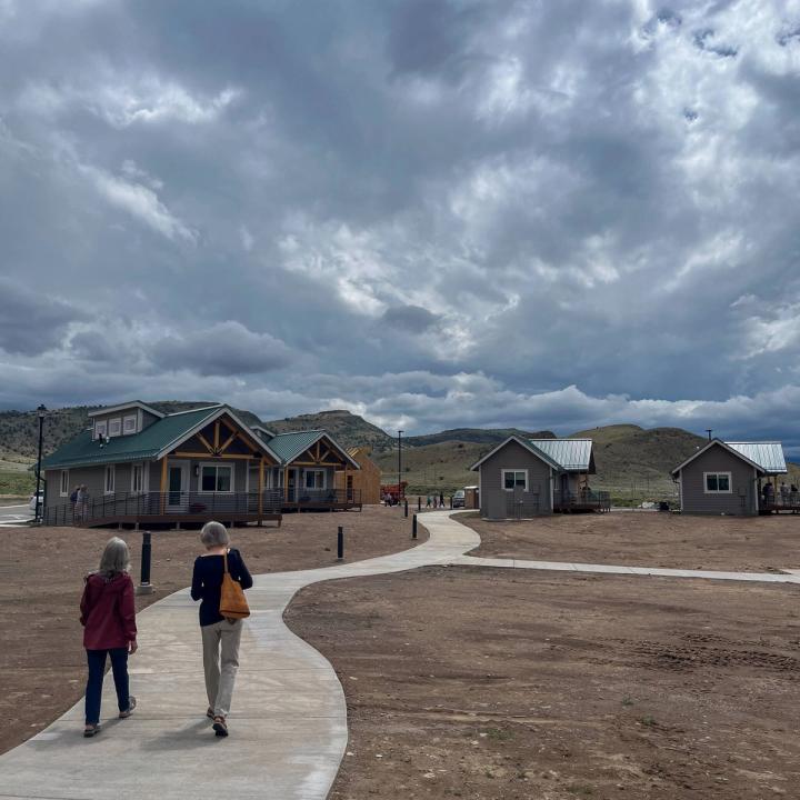 Two women walking down a pathway connecting the wellness center to the casitas on the property