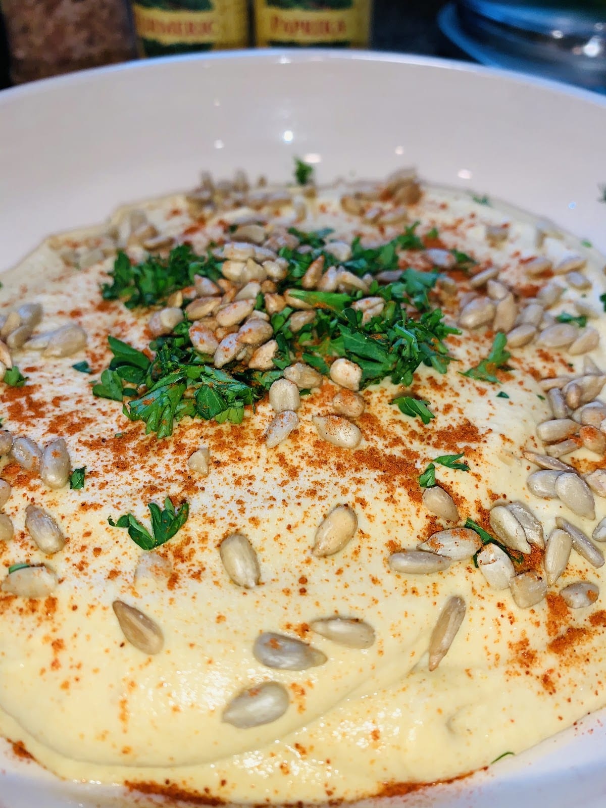 hummus dip topped with paprika sunflower seeds and parsley