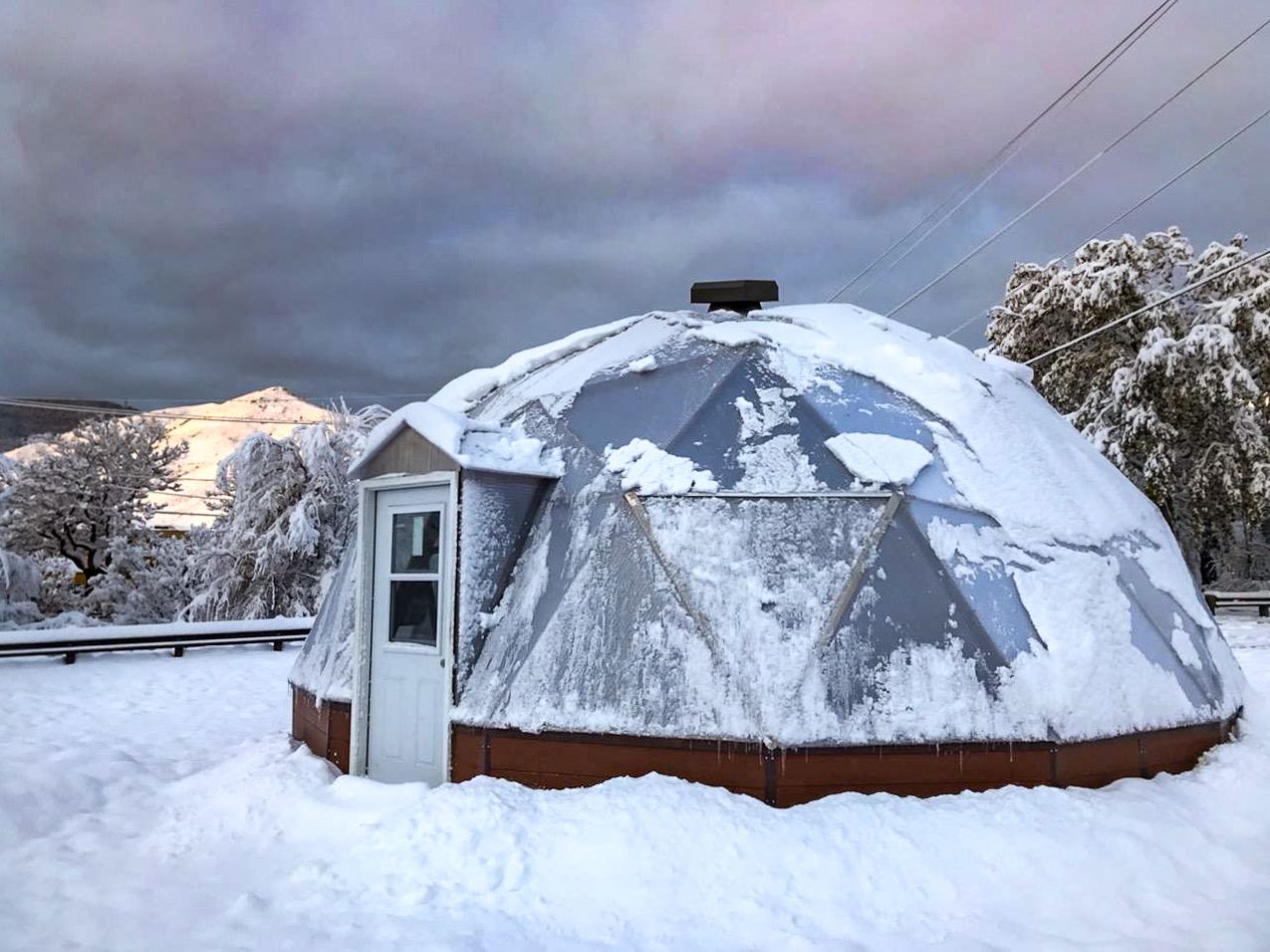 26 foot diameter growing dome geodesic greenhouse under a layer of snow