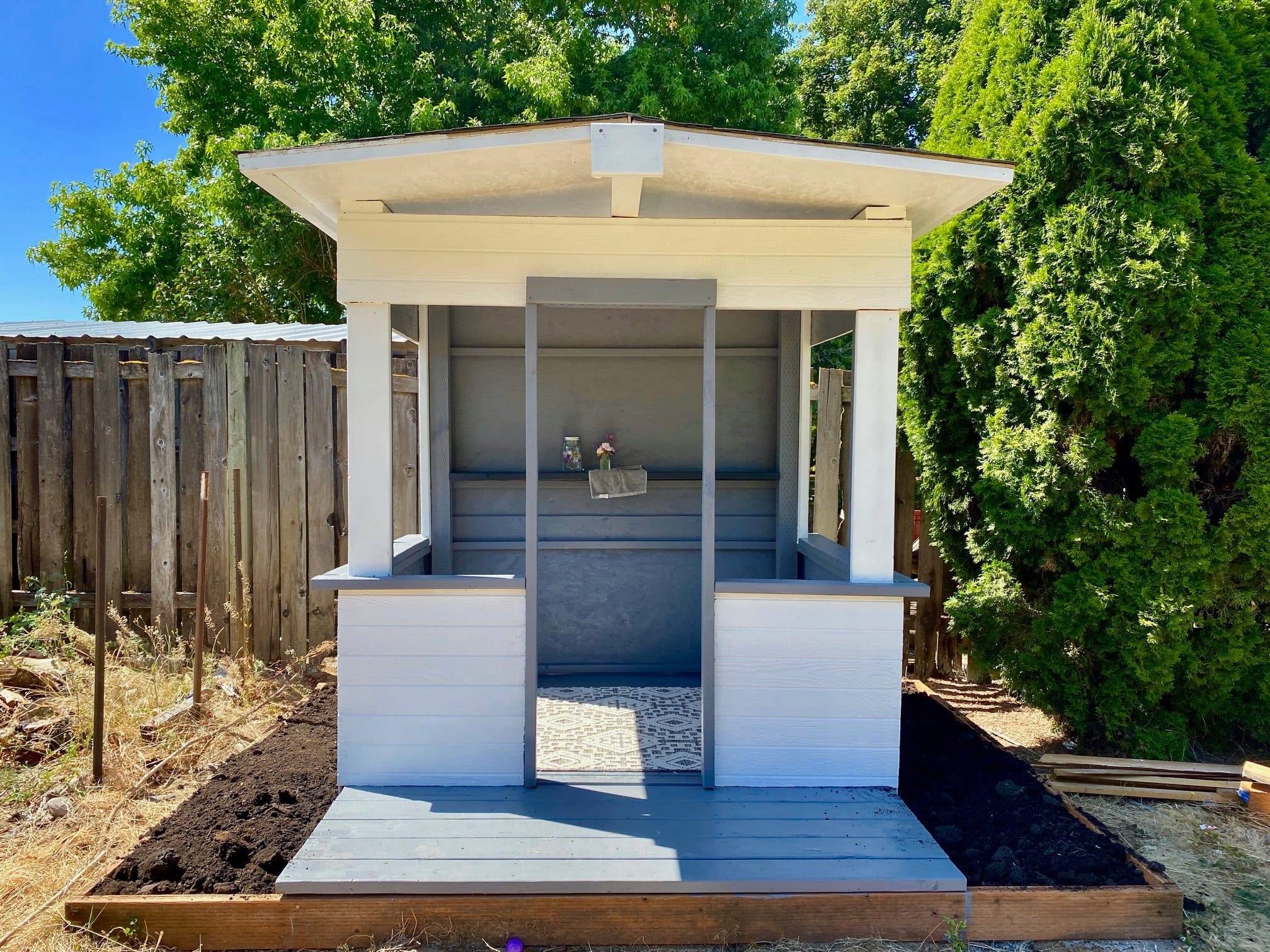 White and gray playhouse made from recycled shipping materials