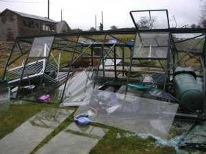 Glass greenhouse damaged by wind