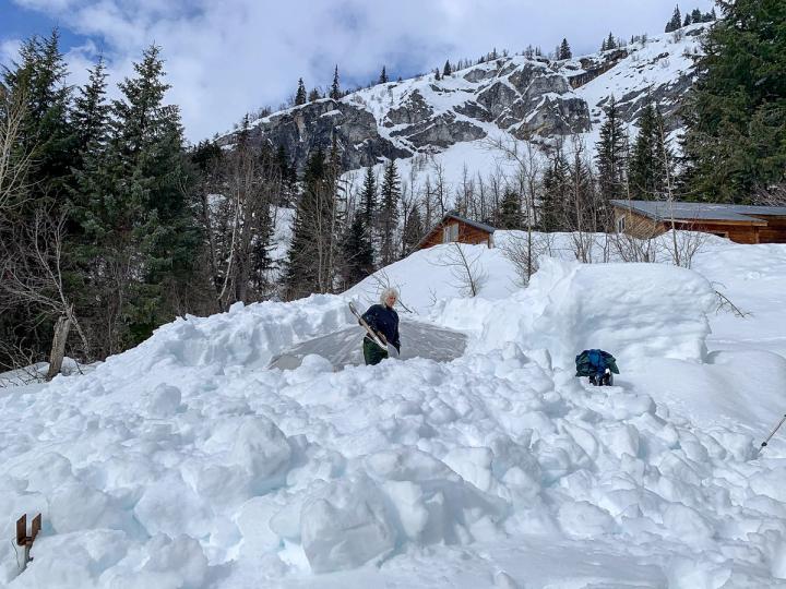 shoveling snow off of a greenhouse in alaska
