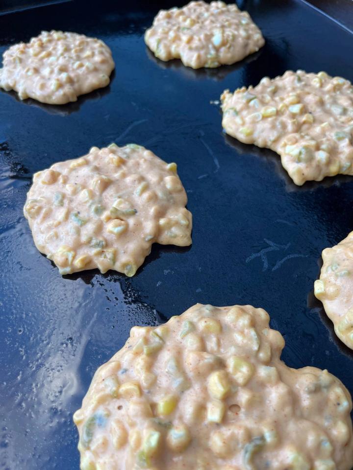 Roasted green chili corn cakes on flat-top grill