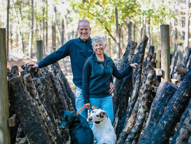 Two growers standing among shiitake mushroom logs at Fogwood Food in Reidsville, North Carolina