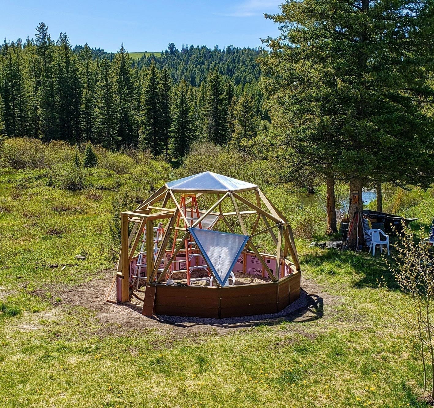 Three people assembling a Growing Dome on a mountain property near Philipsburg, Montana