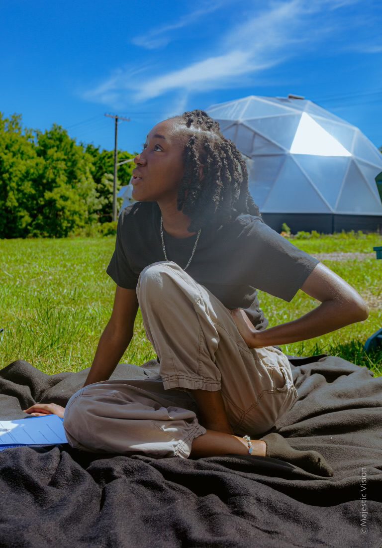 Woman seated on the lawn with the Prolific Oxygen Growing Dome behind her in Cleveland, Ohio