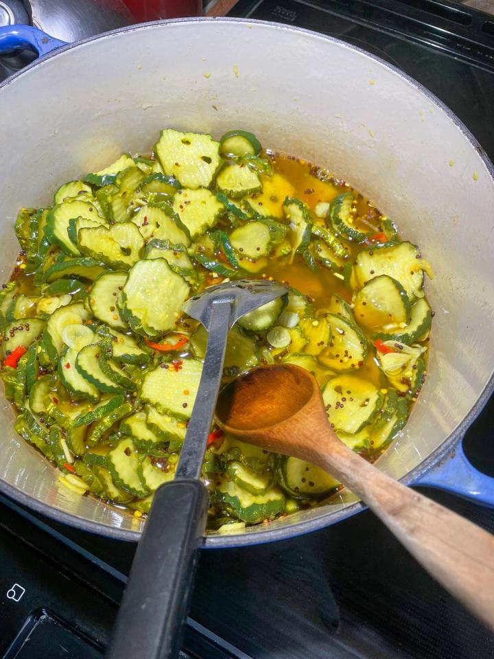 pot of cucumbers in spices and vinegar, tumeric gives it a yellow color
