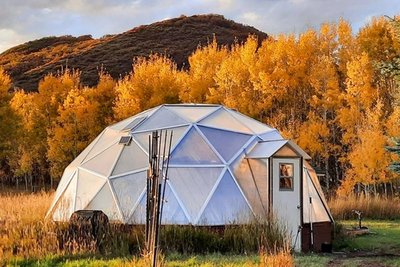 growing dome greenhouse in front of fall colored foliage