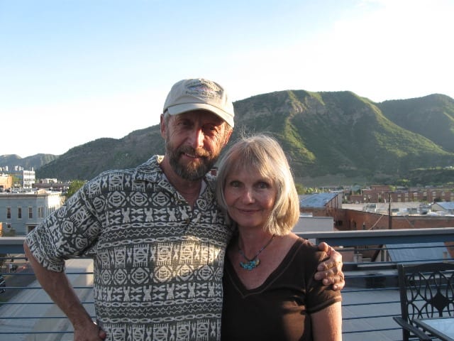 Udgar and Puja Parsons standing in front of a serene mountain backdrop